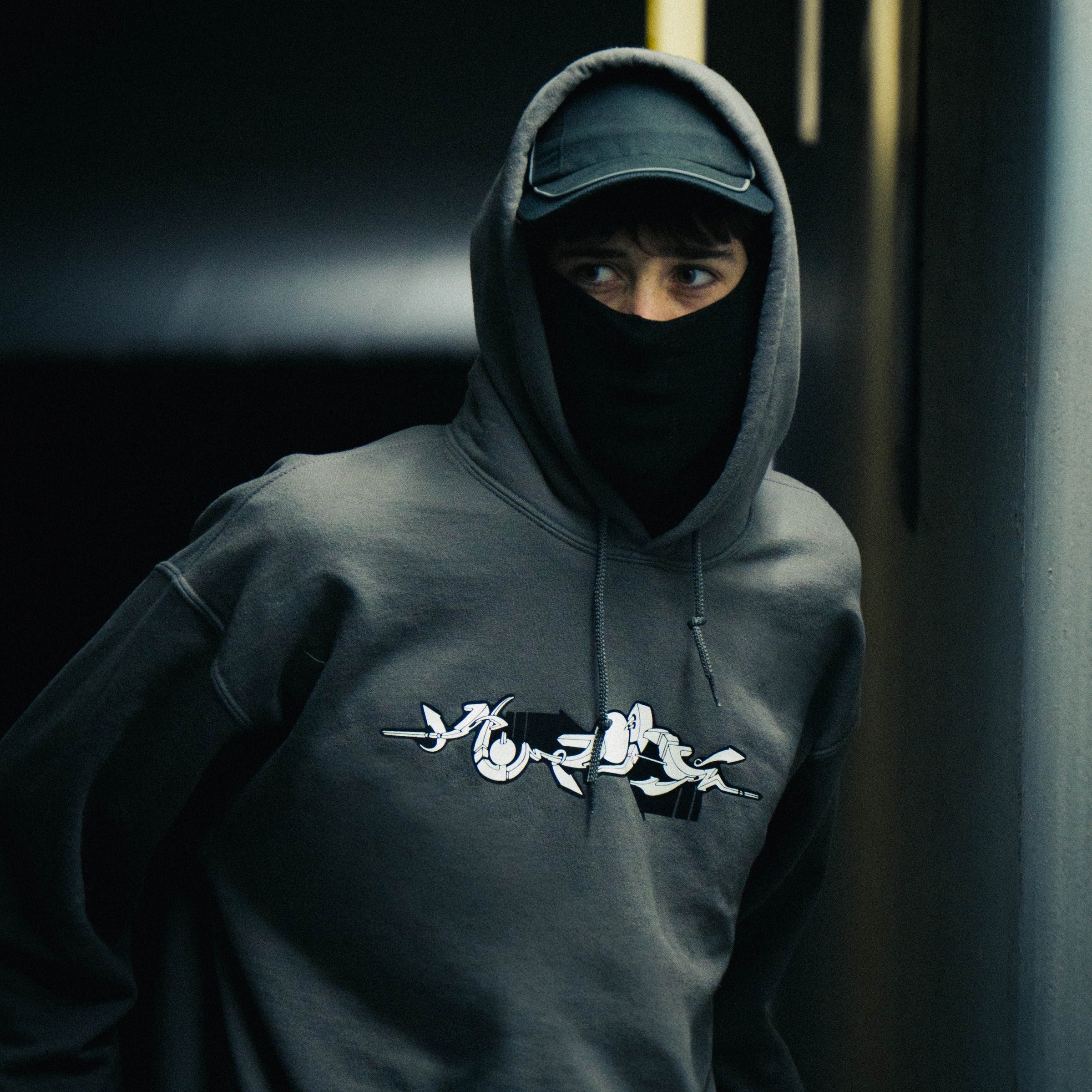 Anthrazit Elektro Hoodie getragen mit Kapuze – weißer Siebdruck auf der Brust